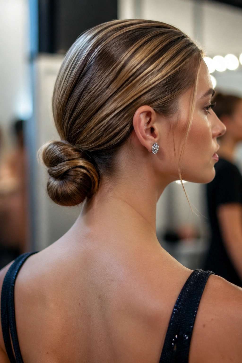 Close-up of a real woman with a low knot ponytail at the nape of the neck