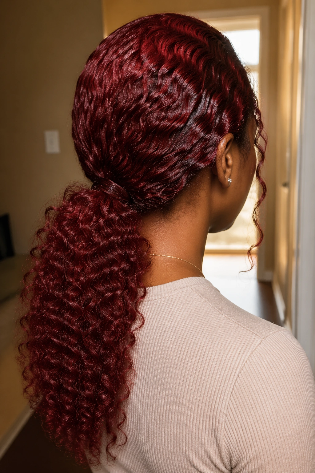 Back view of real person wearing a red lace-front wig with a low ponytail at the nape.