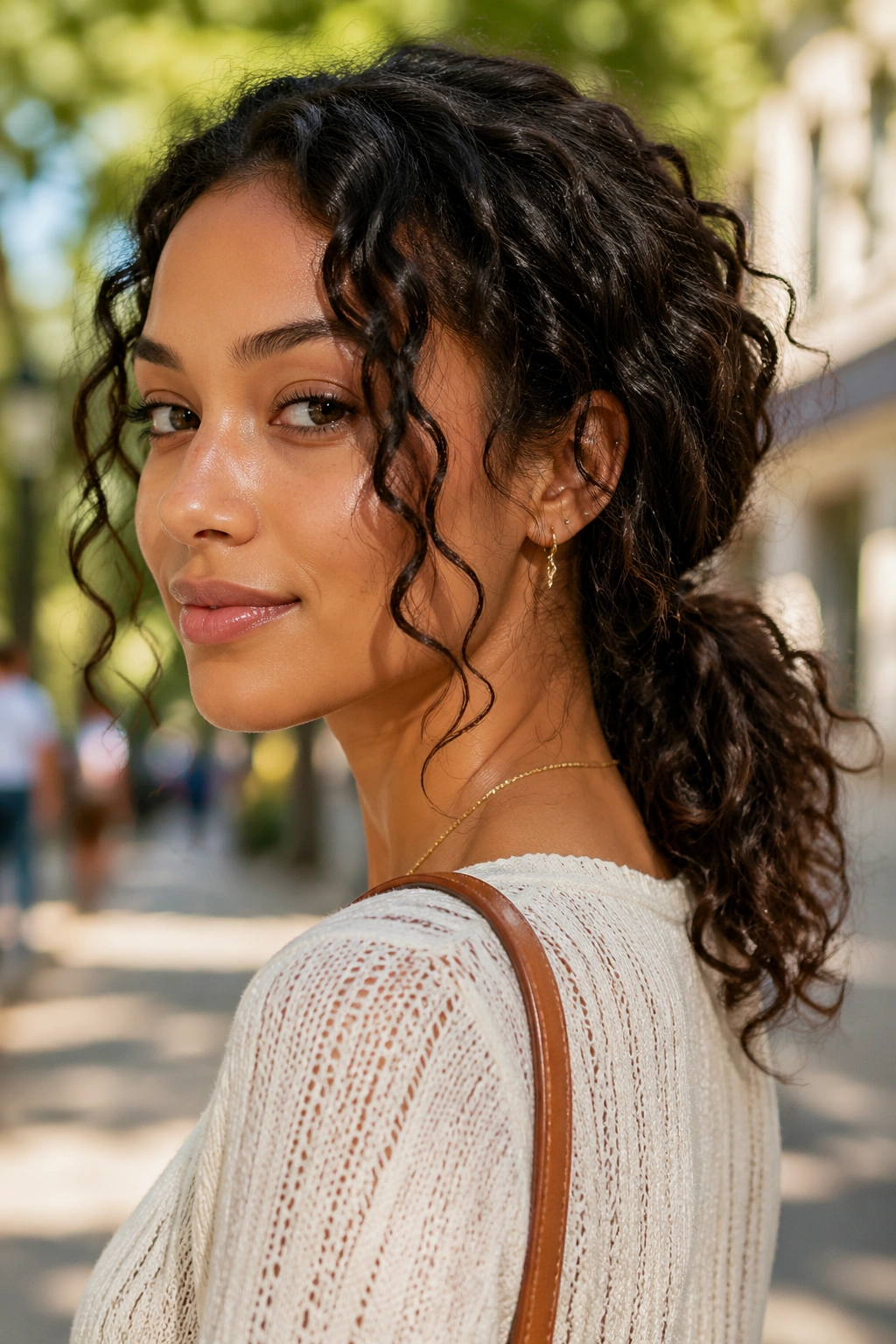 Close-up of real woman with textured low ponytail and curls around face