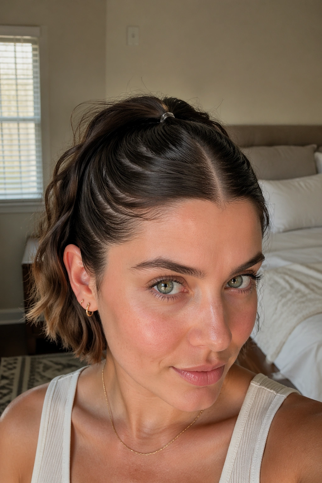 Close-up of a real woman's micro ponytail with a middle part and tiny elastic
