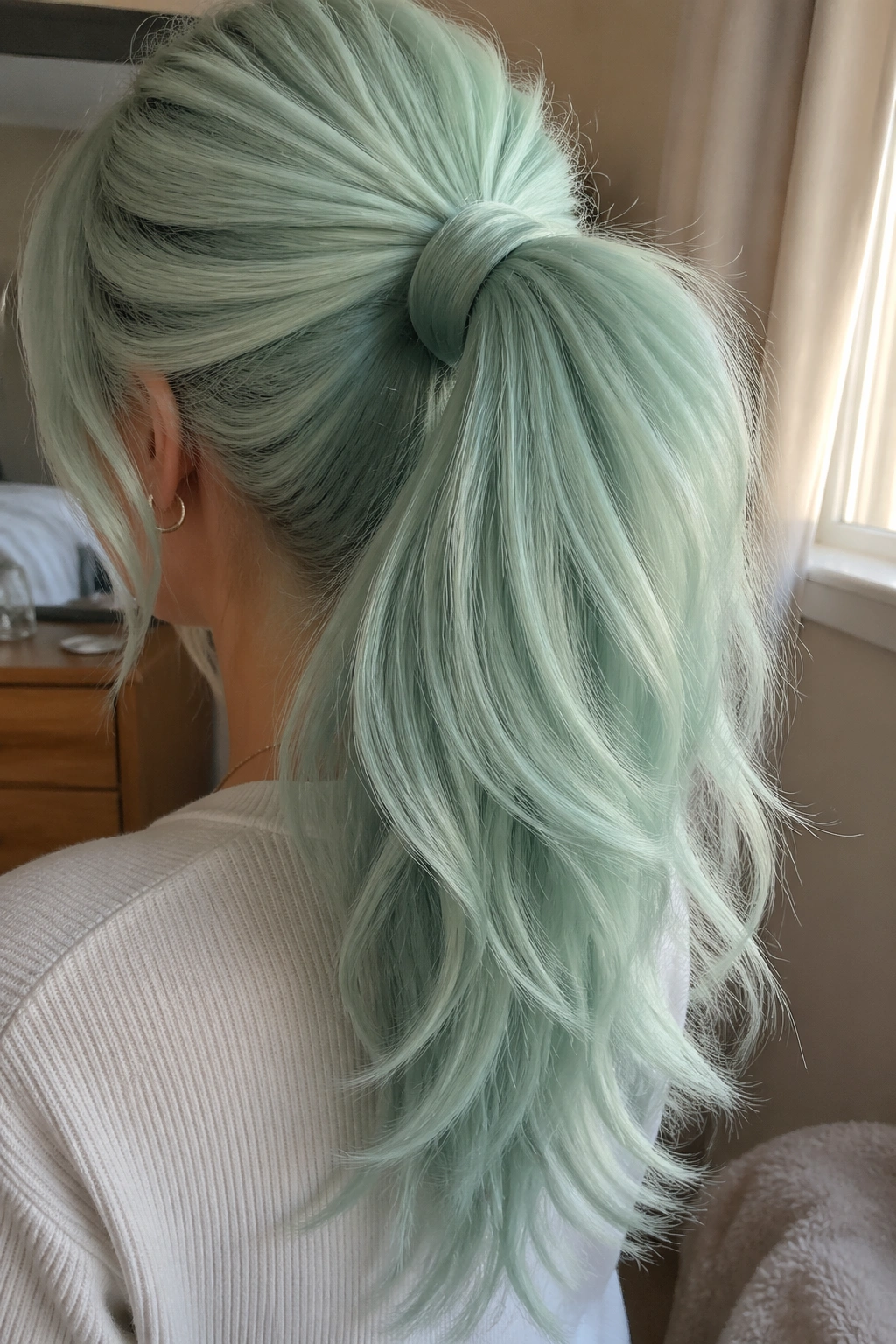 Close-up of mint-green layered ponytail showing texture and volume.