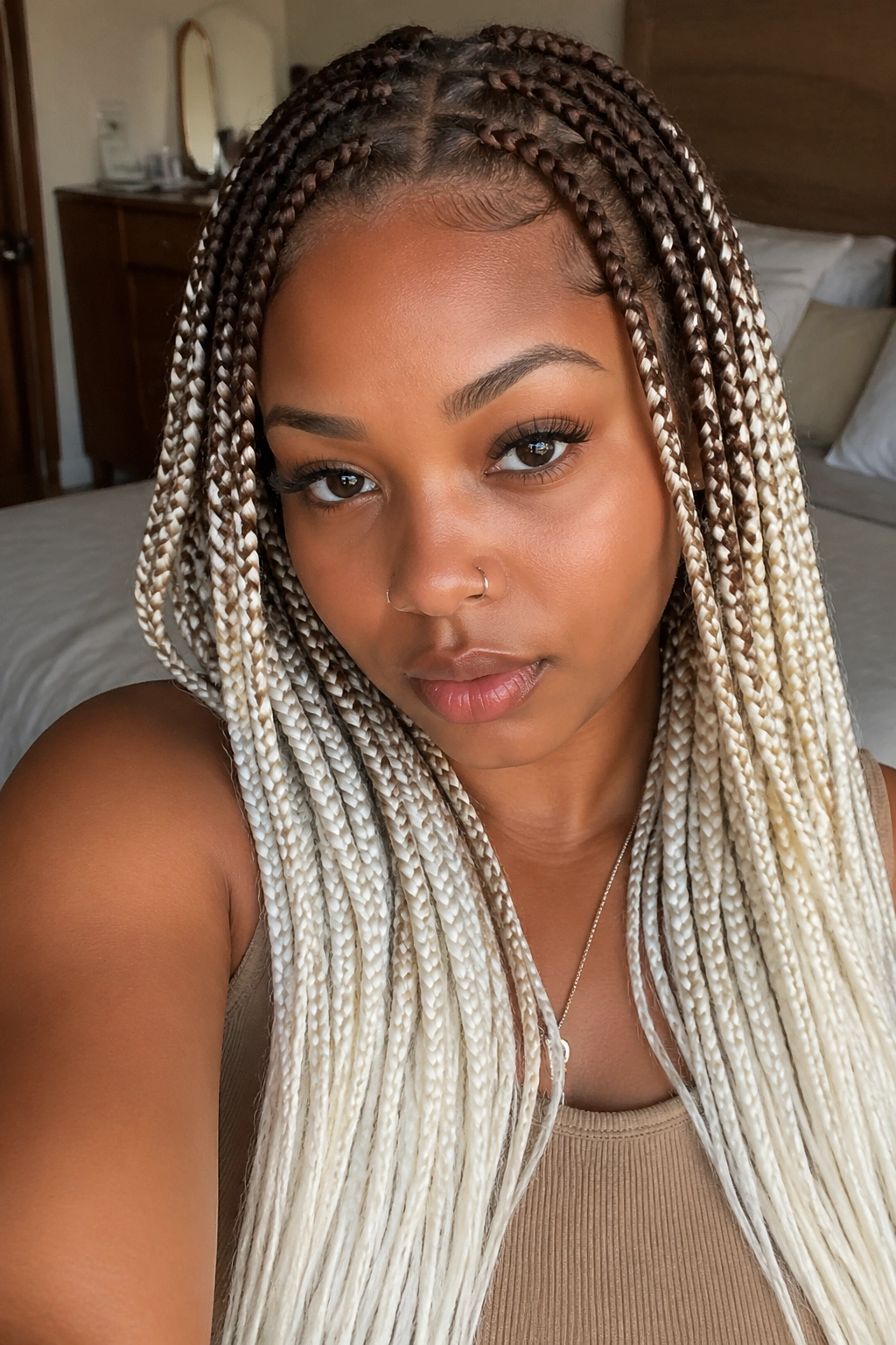 Close-up portrait of a real woman with mocha brown roots and white ends box braids.
