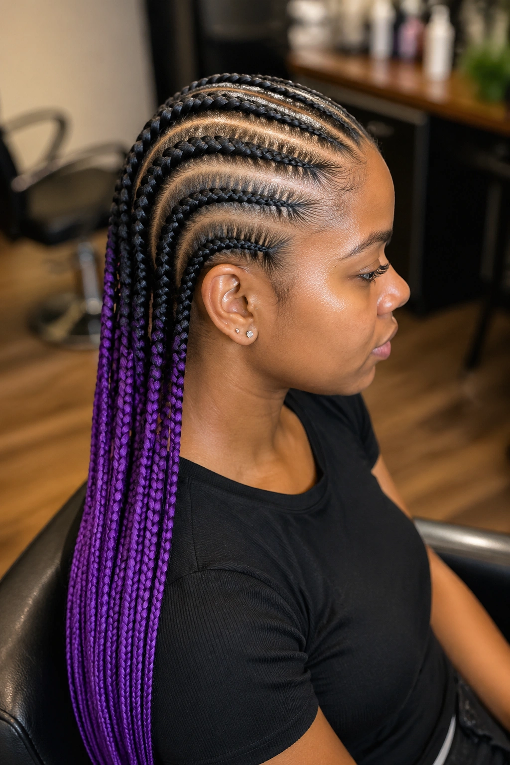 Portrait of a real person with eight to ten ombré cornrows from dark roots to purple ends.