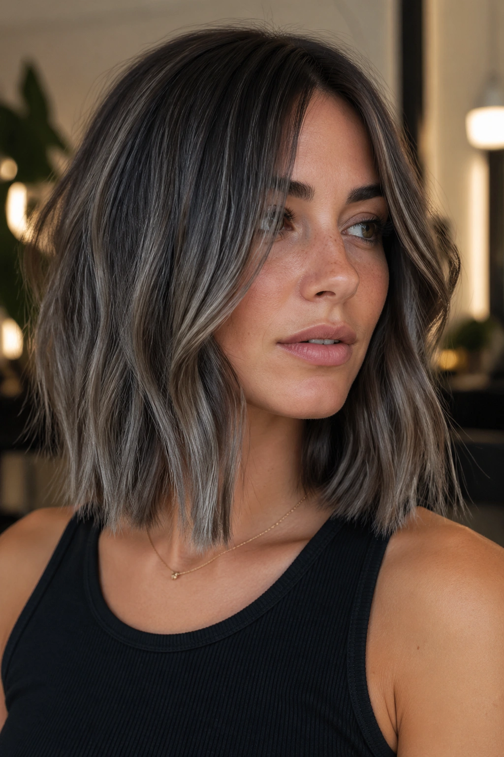 Close-up of a real woman with a blunt one-length lob and smoky ash streaks