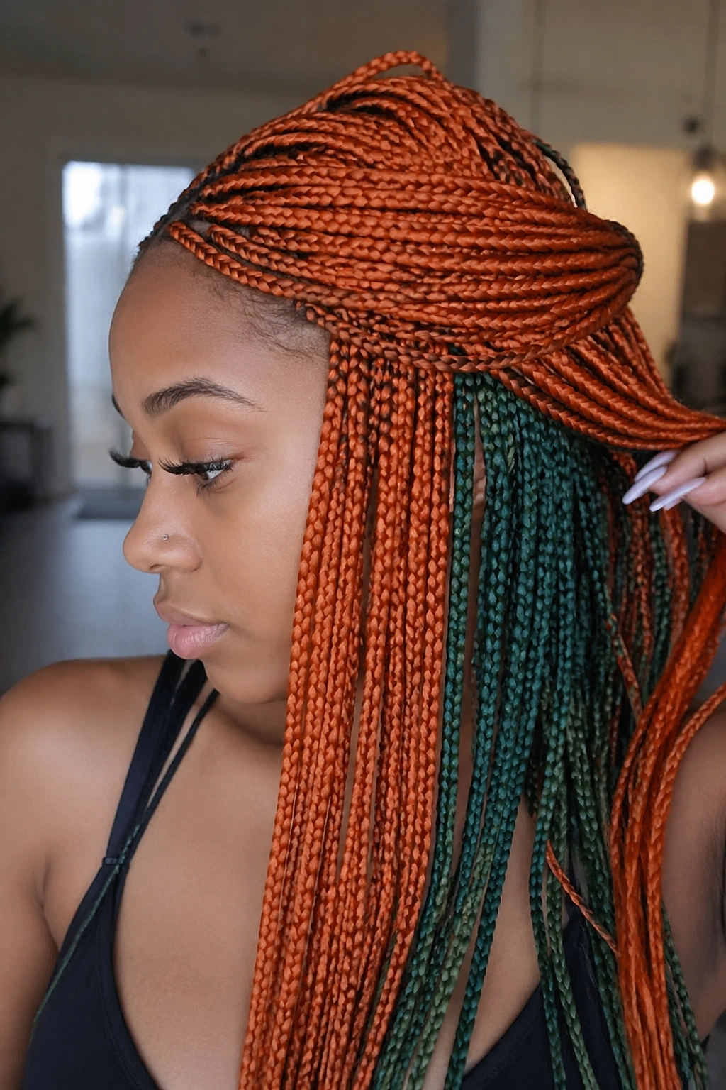 Close-up of orange top-layer braids with hidden green beneath on a real person