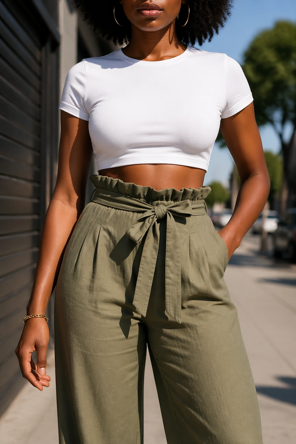 Portrait of a woman in crop top and paperbag waist trousers outdoors