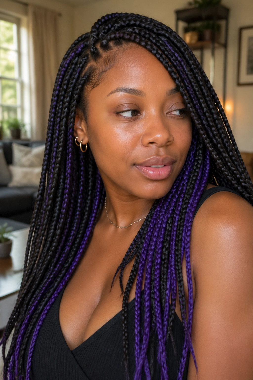 Close-up portrait showing peekaboo purple braids under the top layer on a real person