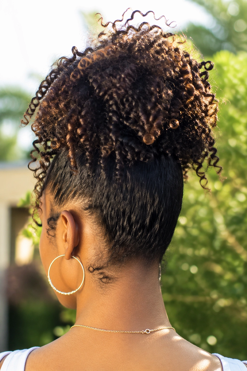 Back-of-head view of a woman with a pineapple ponytail.