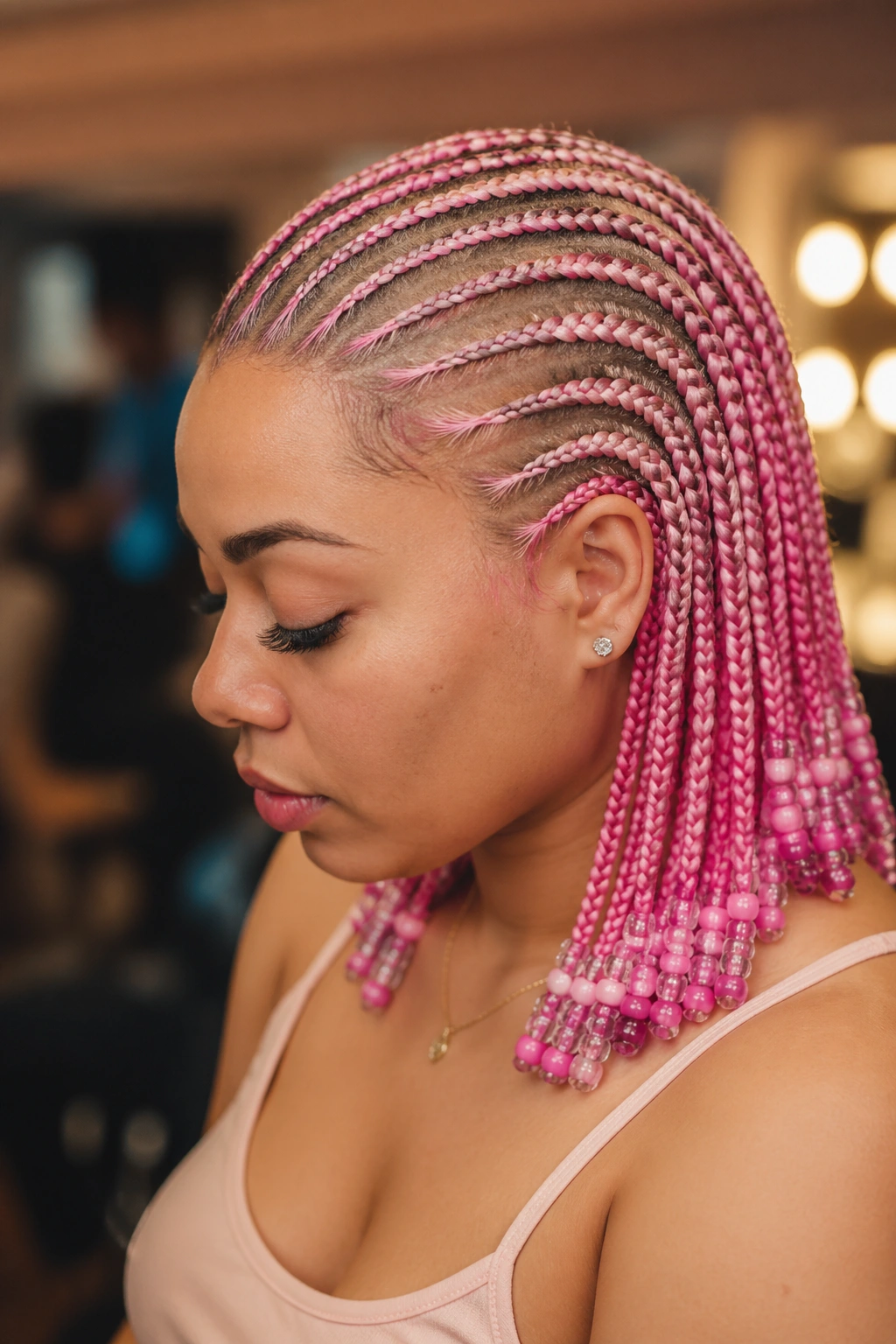 Close-up of a real woman with pink cornrows ending in beads