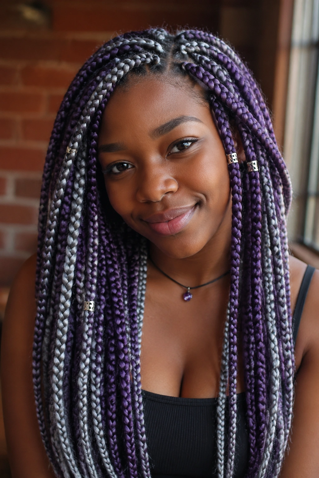 Close-up portrait of a real woman with purple and silver two-tone box braids in warm cafe lighting