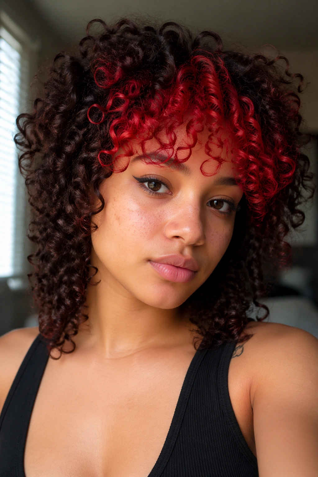 Close-up of a real woman's curly hair with bold red bangs