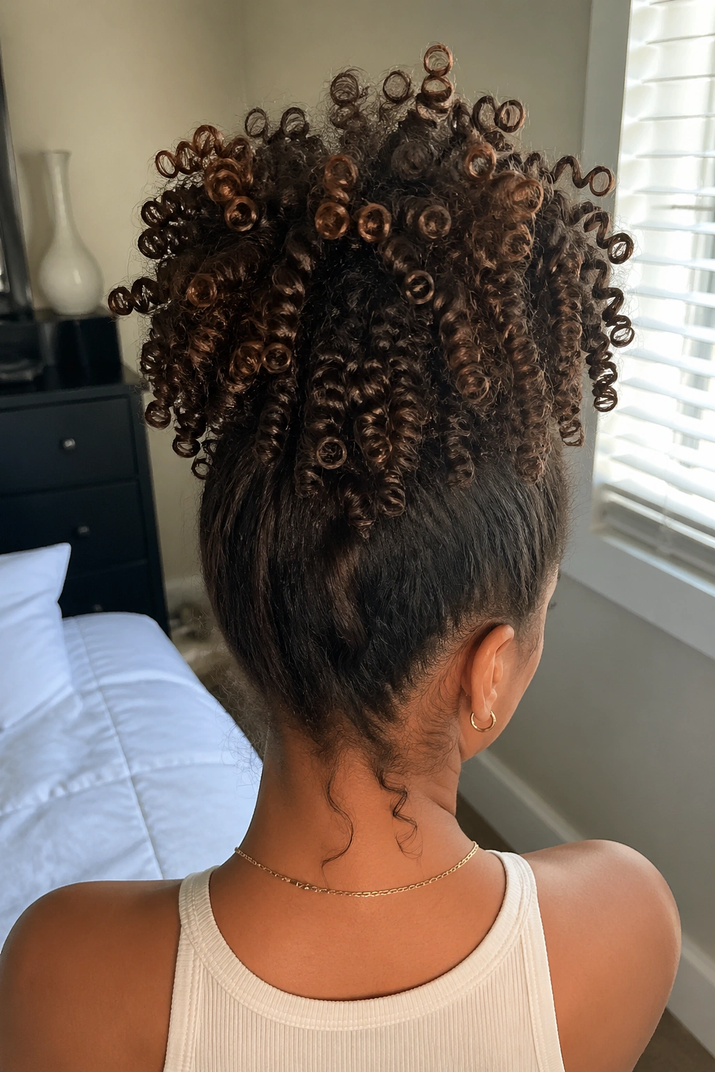 Back view of a real woman with a high pineapple of ringlet curls