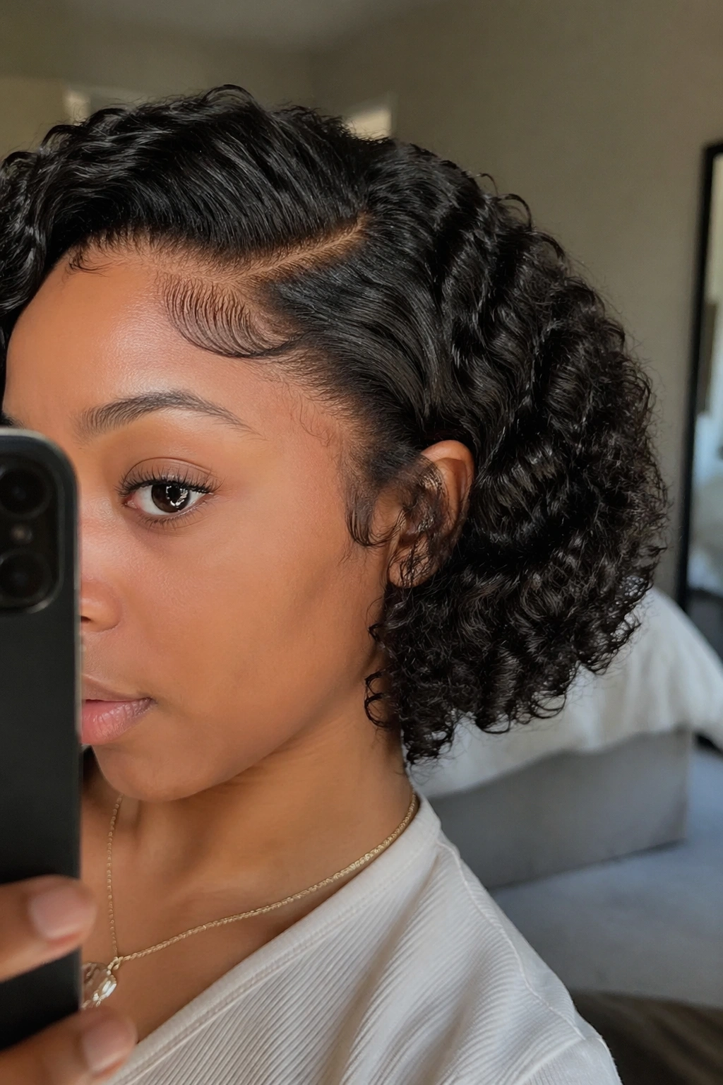 Close-up of rounded bob curls on a lace-front wig in a softly lit bedroom mirror.
