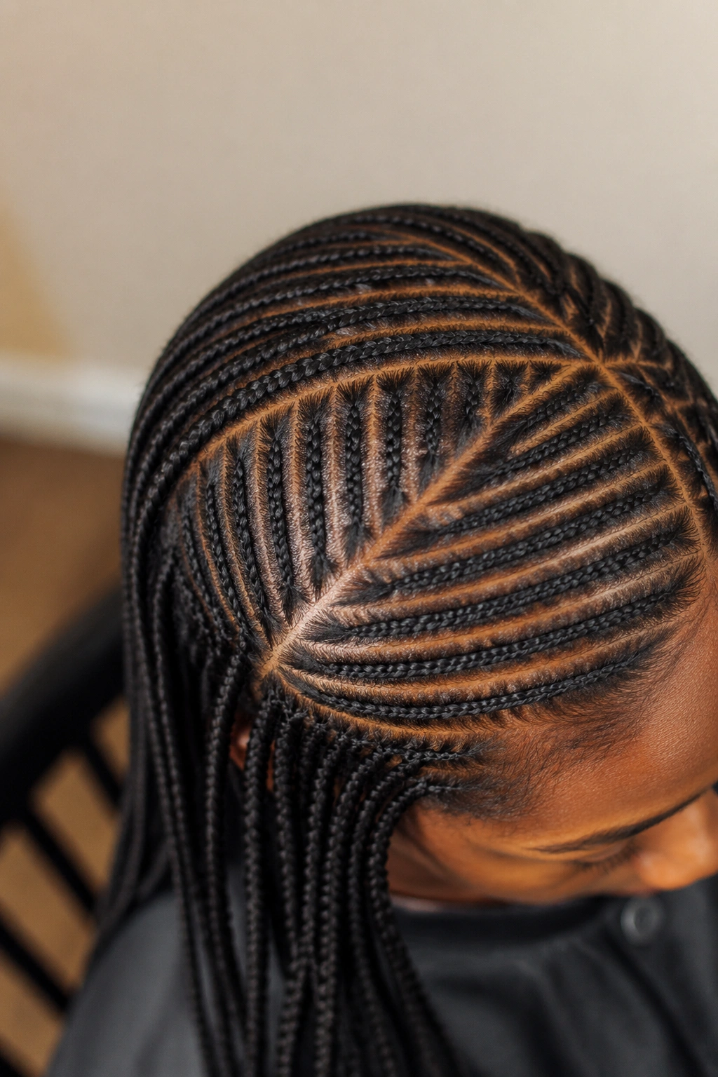 Close-up of scalp with neat part lines for dense small-cornrow patterns.