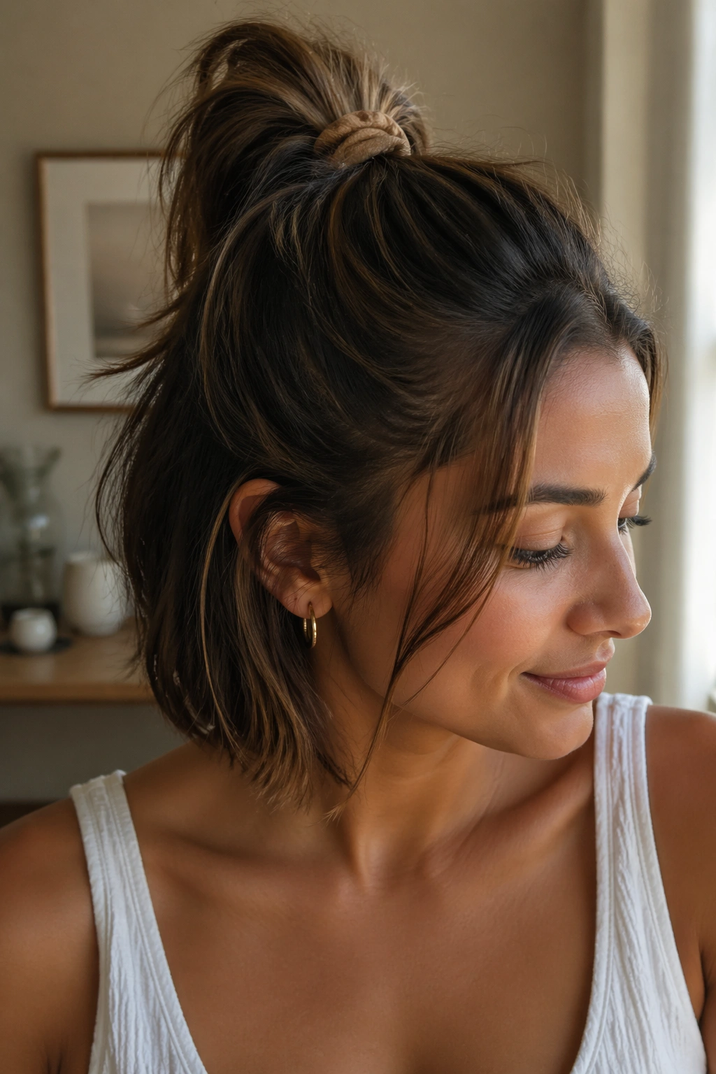Portrait of a short-haired person with a compact half-up ponytail using a small elastic.