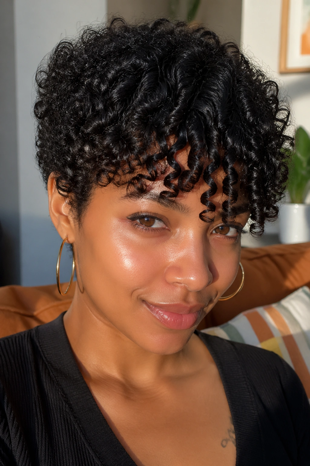Close-up of a real person with short natural curls and bangs across the forehead
