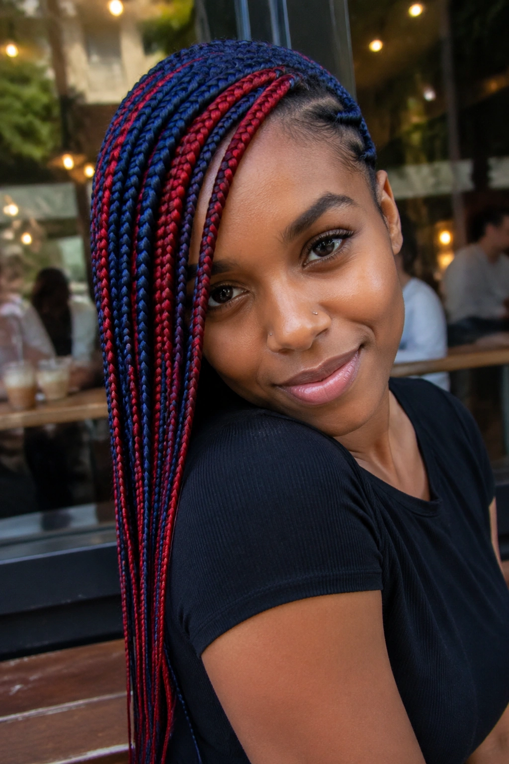 Portrait of a real woman with side-swept blue and red braids.