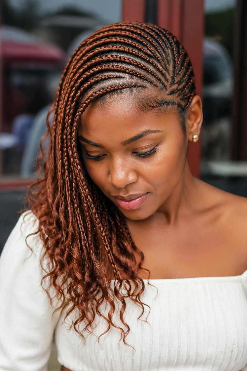 Side-swept auburn cornrows on a real person with diagonal part