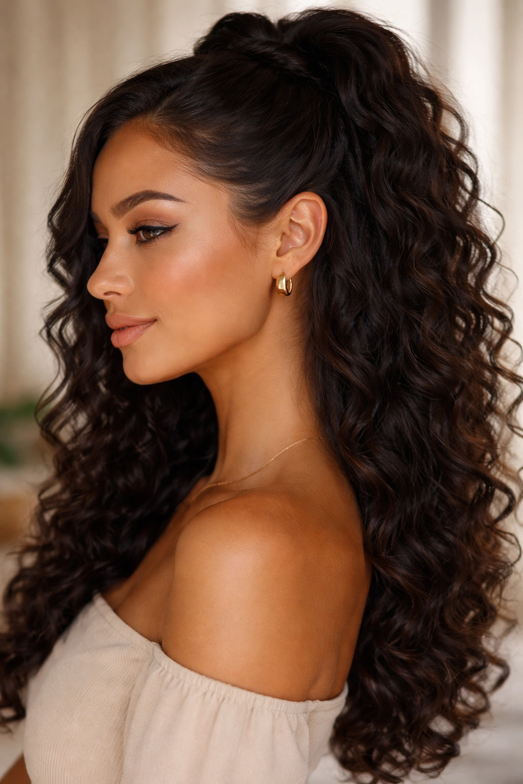 Side-tucked half-up hairstyle behind the ear showing curls