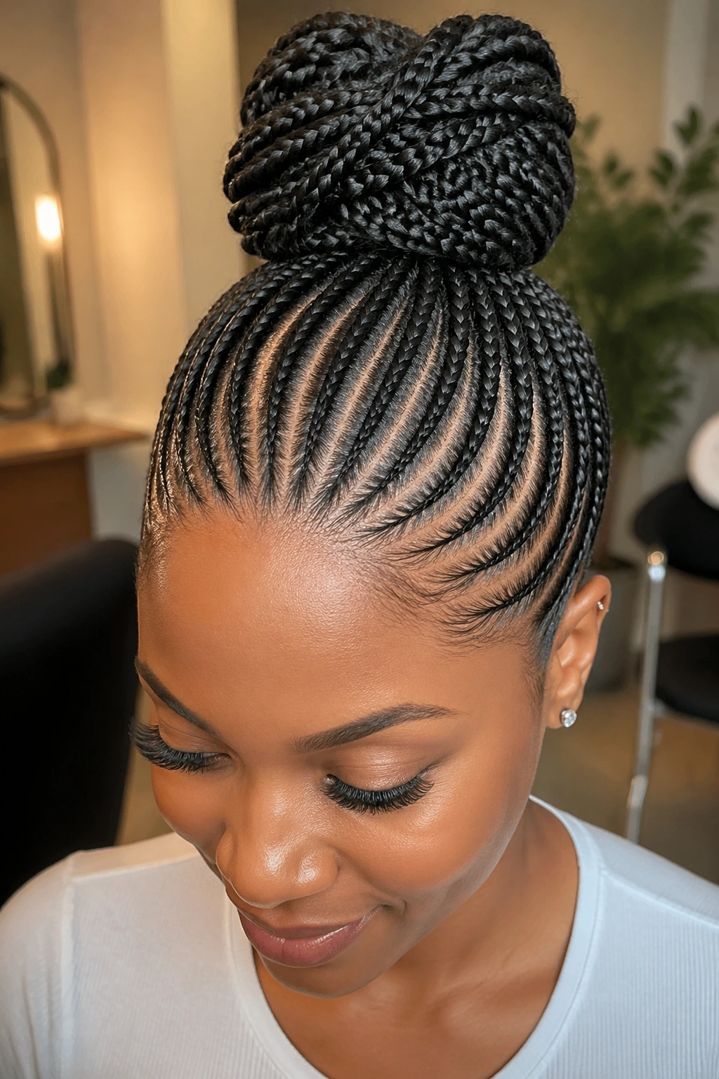 Close-up of small cornrows forming a crown bun on a real woman with warm lighting