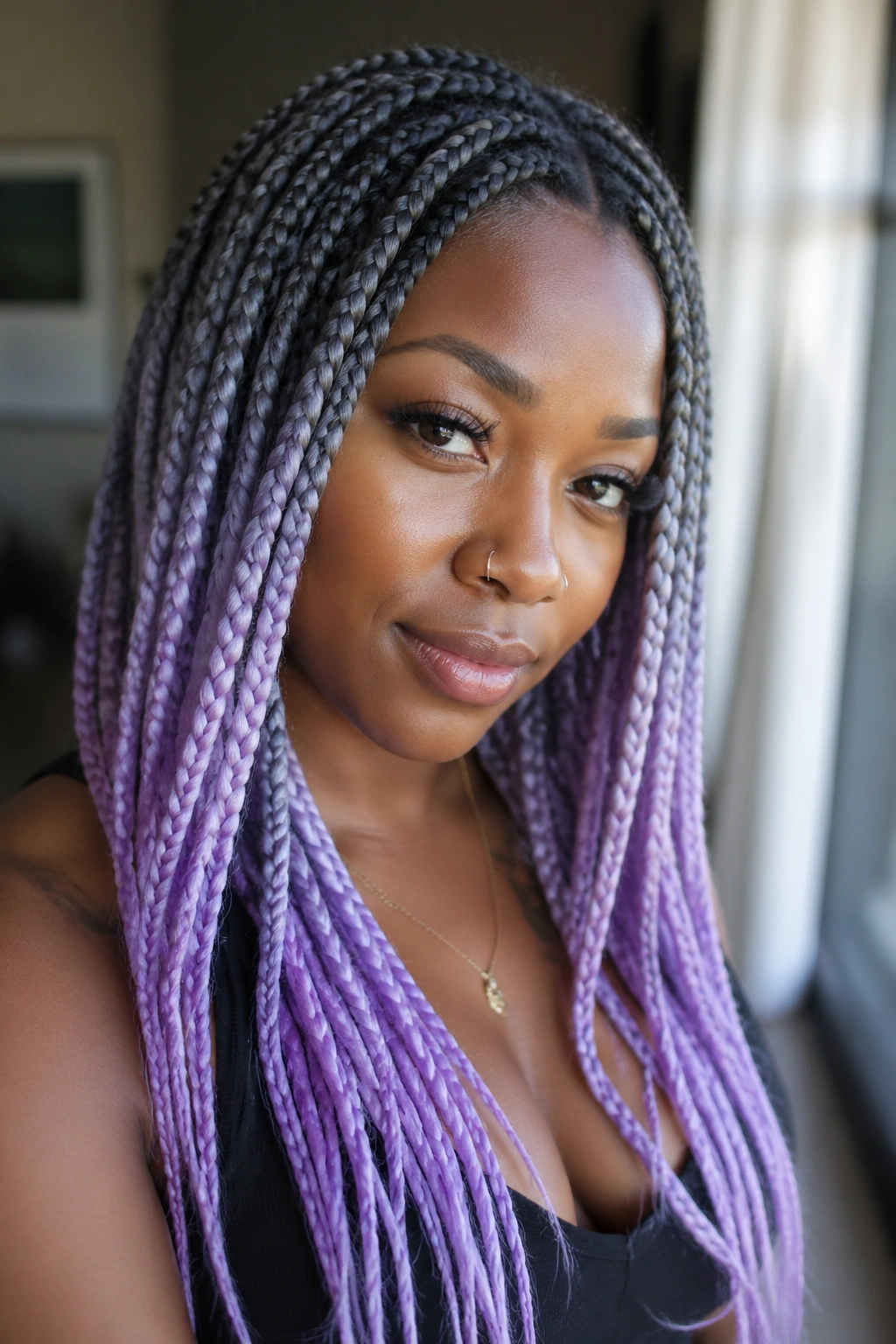 Close-up of a real woman with smoky grey roots and lilac-tipped box braids.