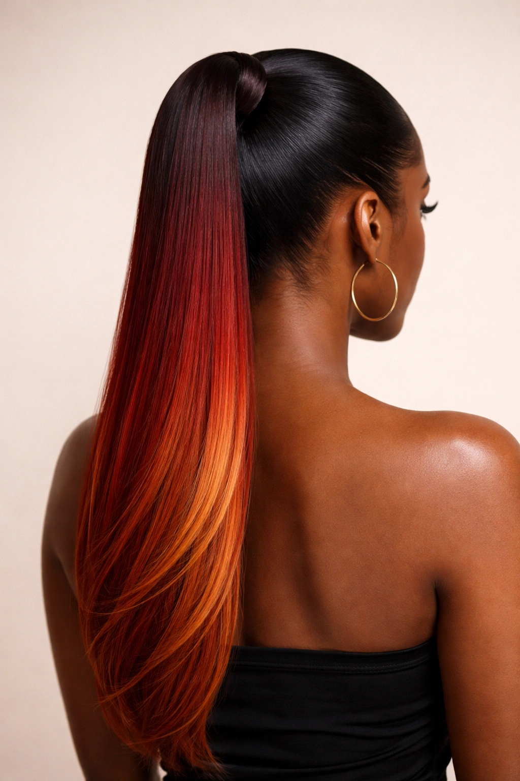 Sunset red gradient ponytail in a high sleek pony against a neutral backdrop