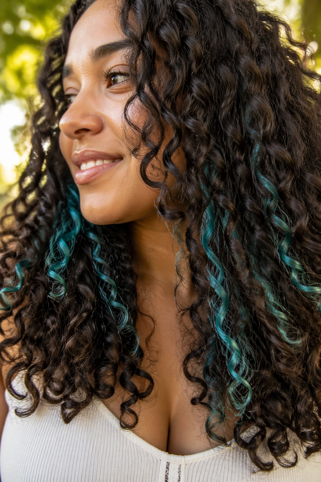 Close-up of teal peekaboo panels visible under curly hair