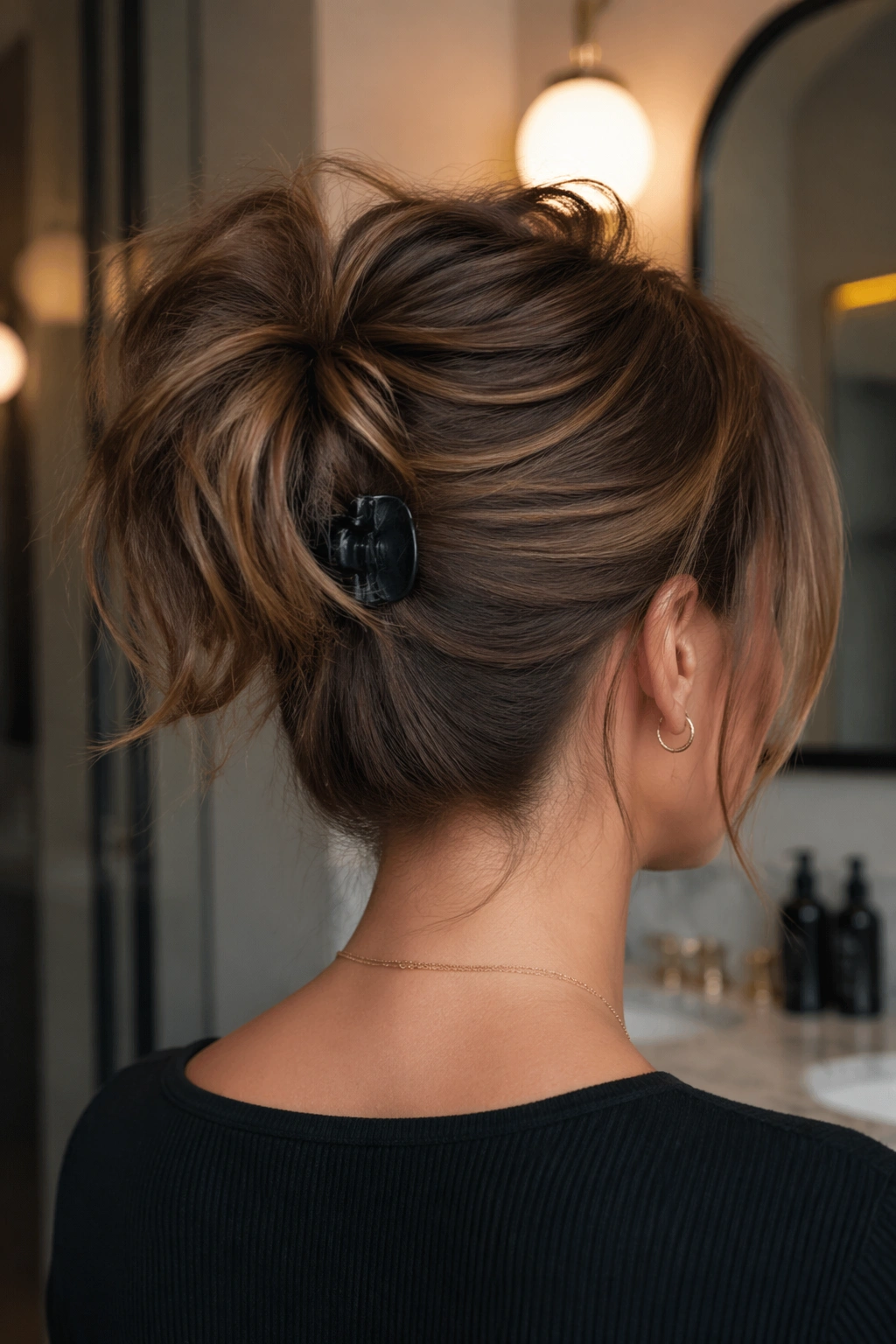 Medium close-up of a real person showing a textured ponytail with a claw clip lift