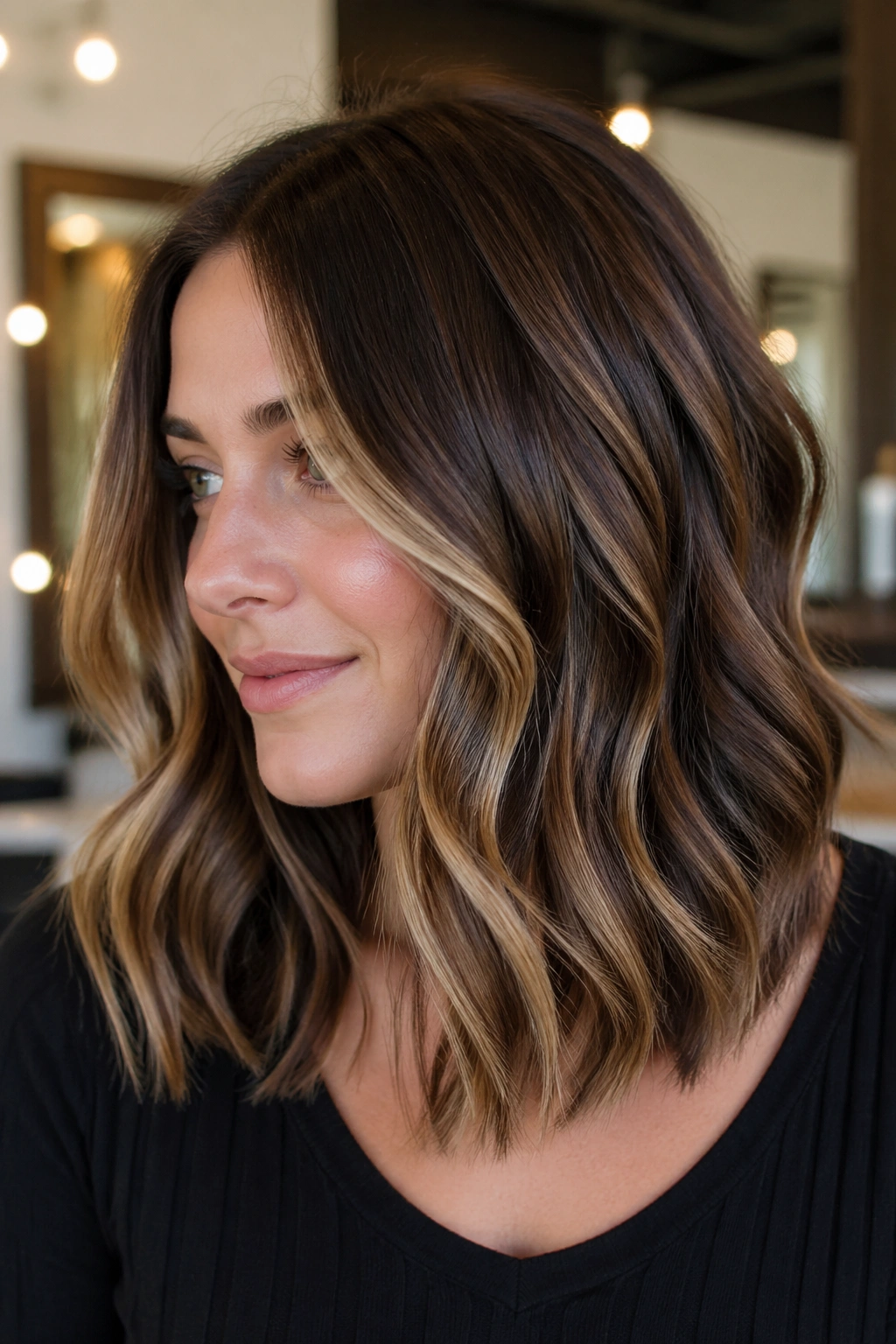 Close-up of a real woman with a thick wavy lob and butterscotch panels