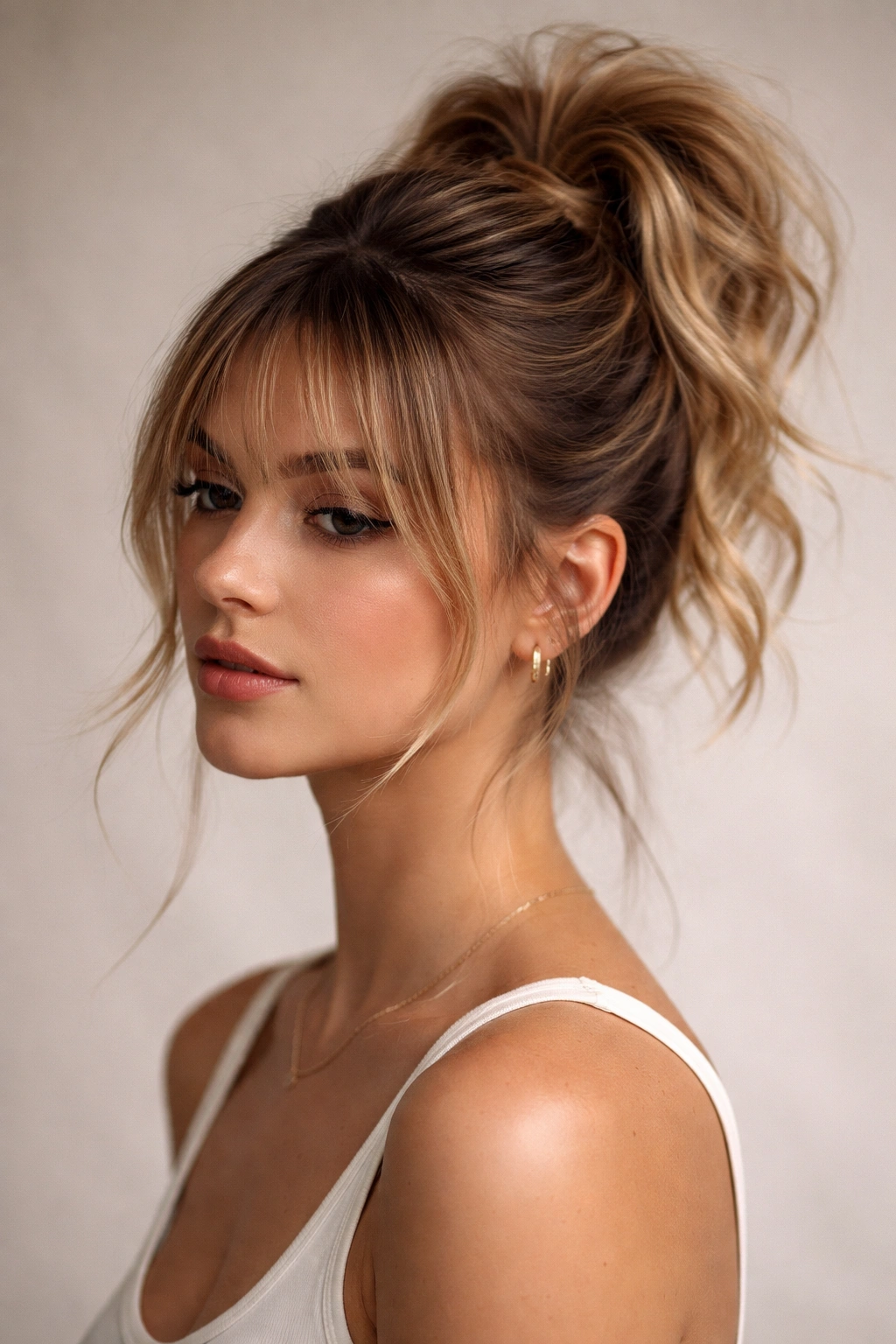 Close-up of a messy topknot ponytail with bottleneck bangs and lifted crown