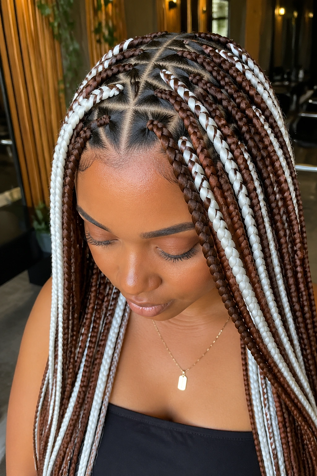 Real woman with triangle-part brown and white box braids in a salon setting.