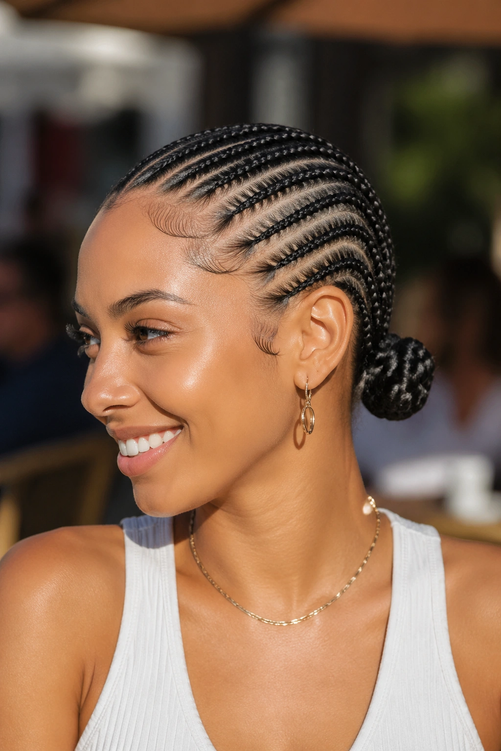 Real woman with straight-back cornrows ending in two symmetric nape buns.