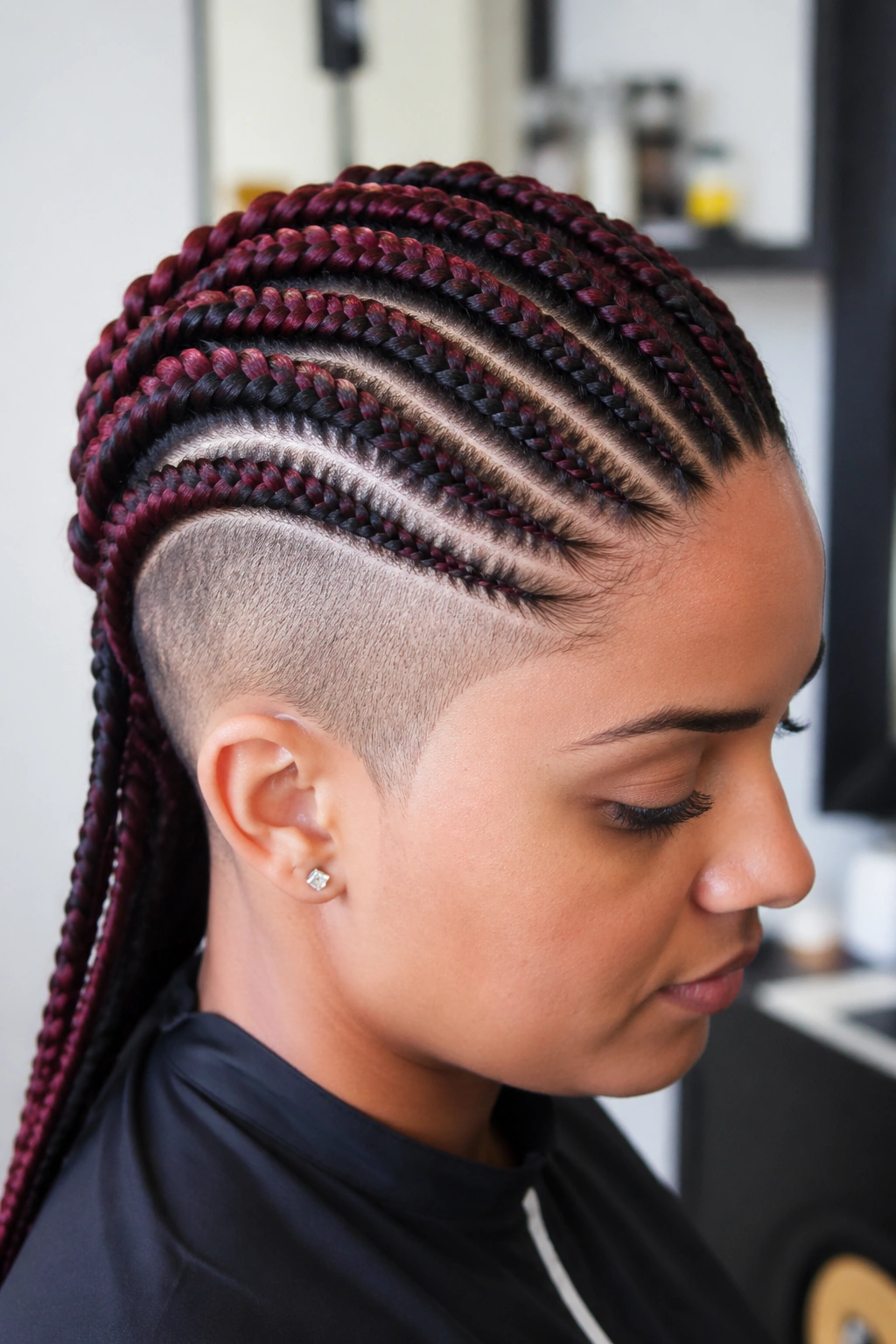 Close-up portrait of a real person with two-tone cornrows and shaved side.