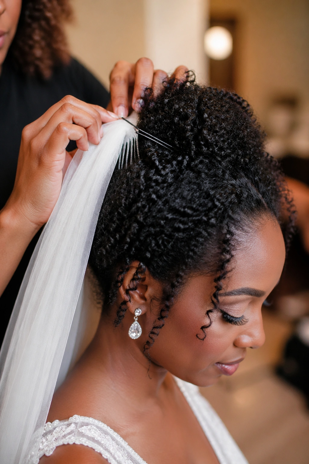 Close-up of bride with veil secured into curly updo with pins
