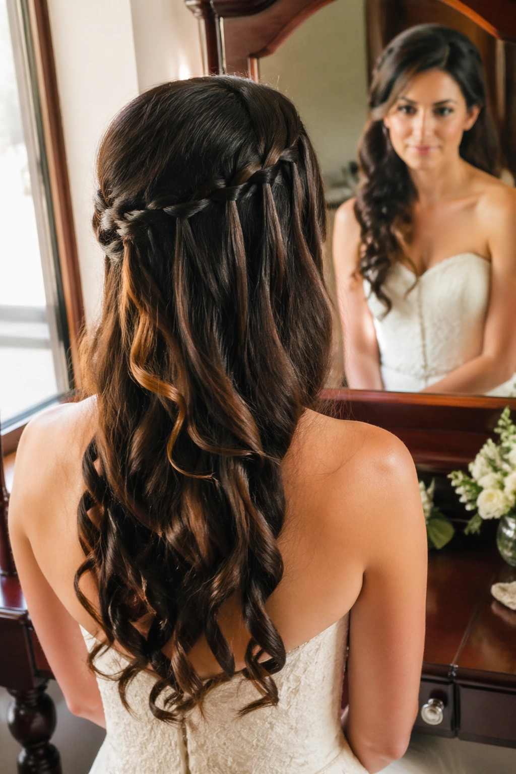Waterfall braid along one side of brunette with loose curls.
