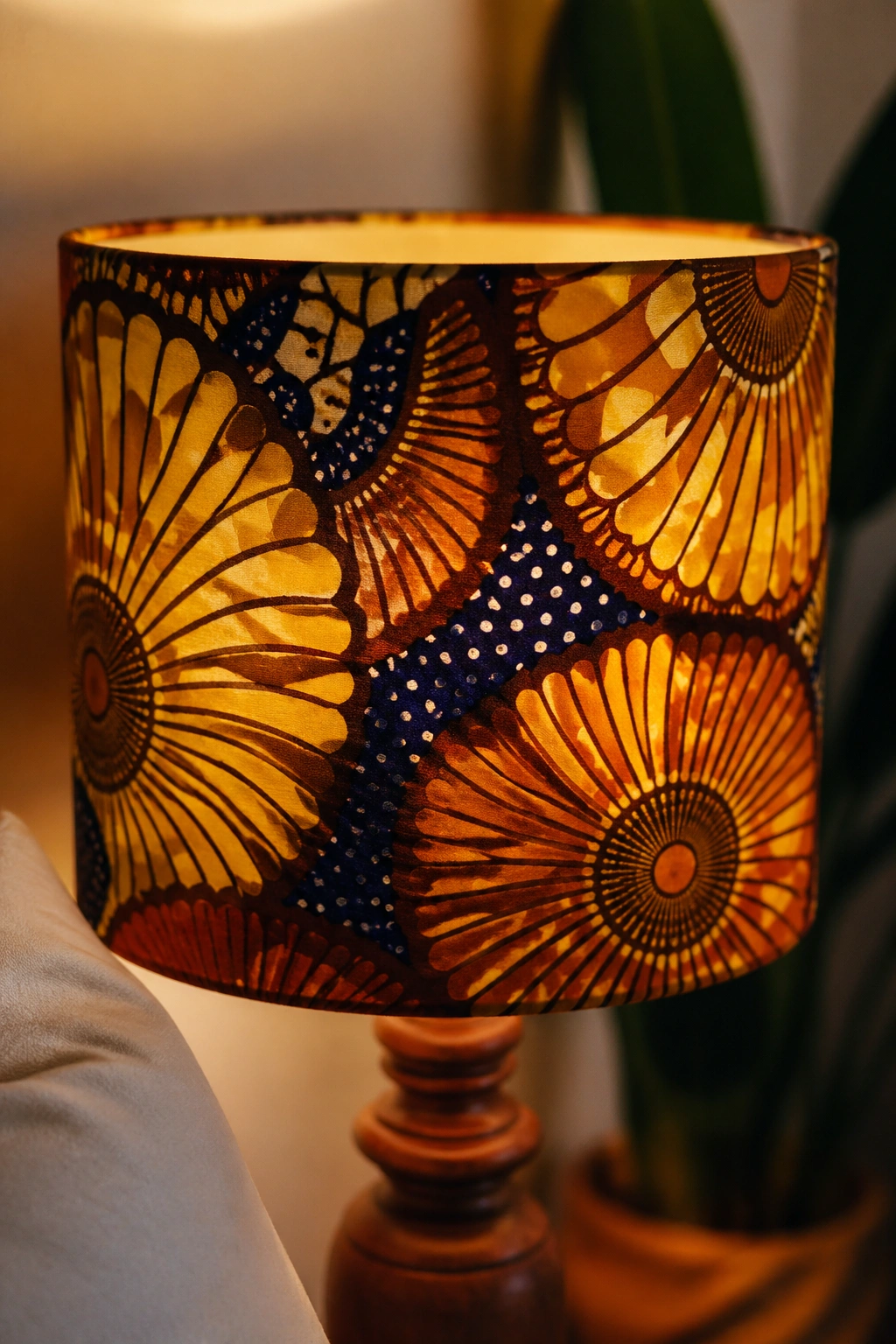 Lampshade wrapped in African wax print fabric lit warmly