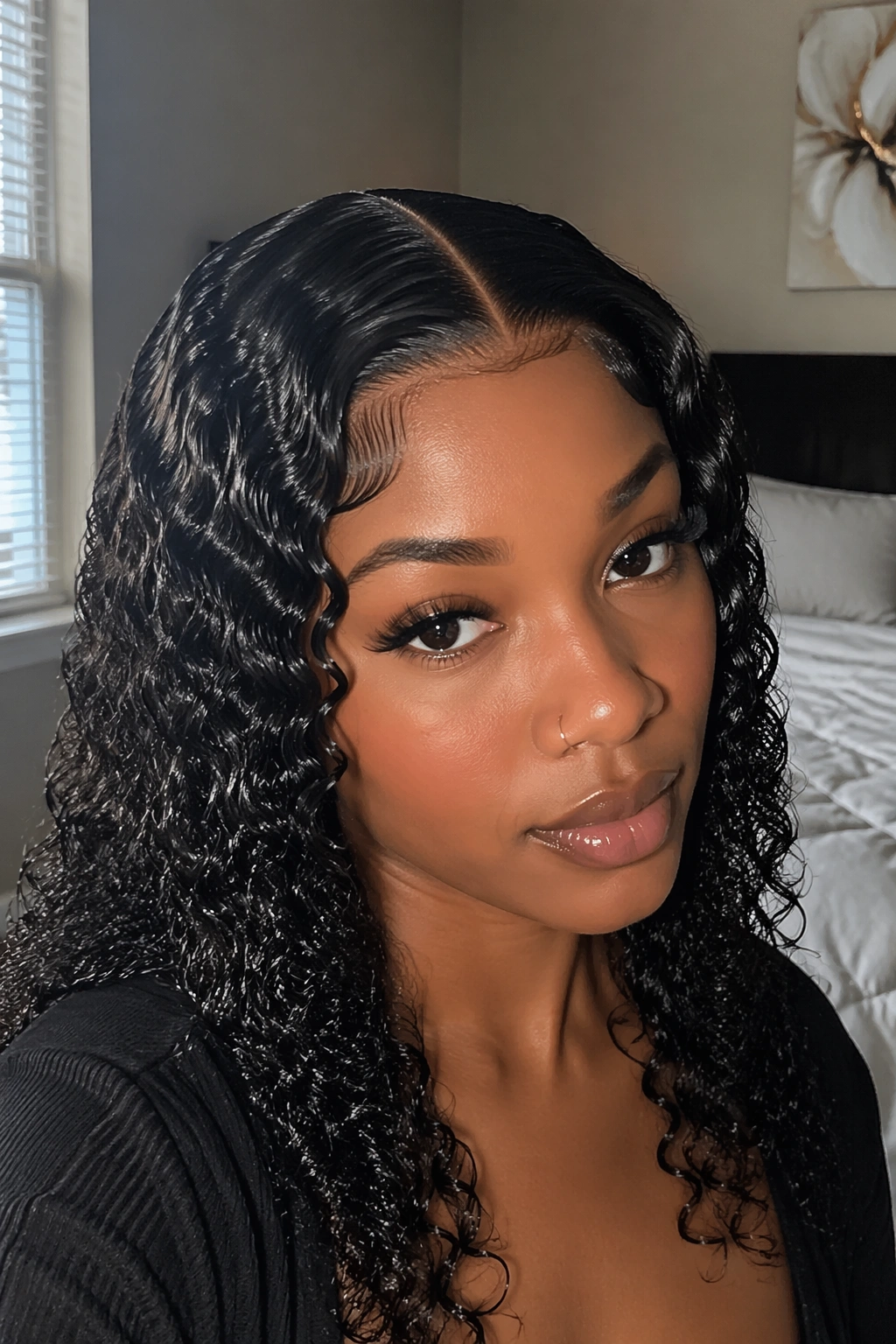 Close-up of wet-look curls with a sharp part on a real person.