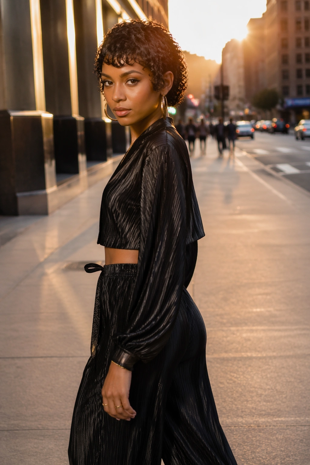 Glossy wet-look curls on a city street at golden hour.