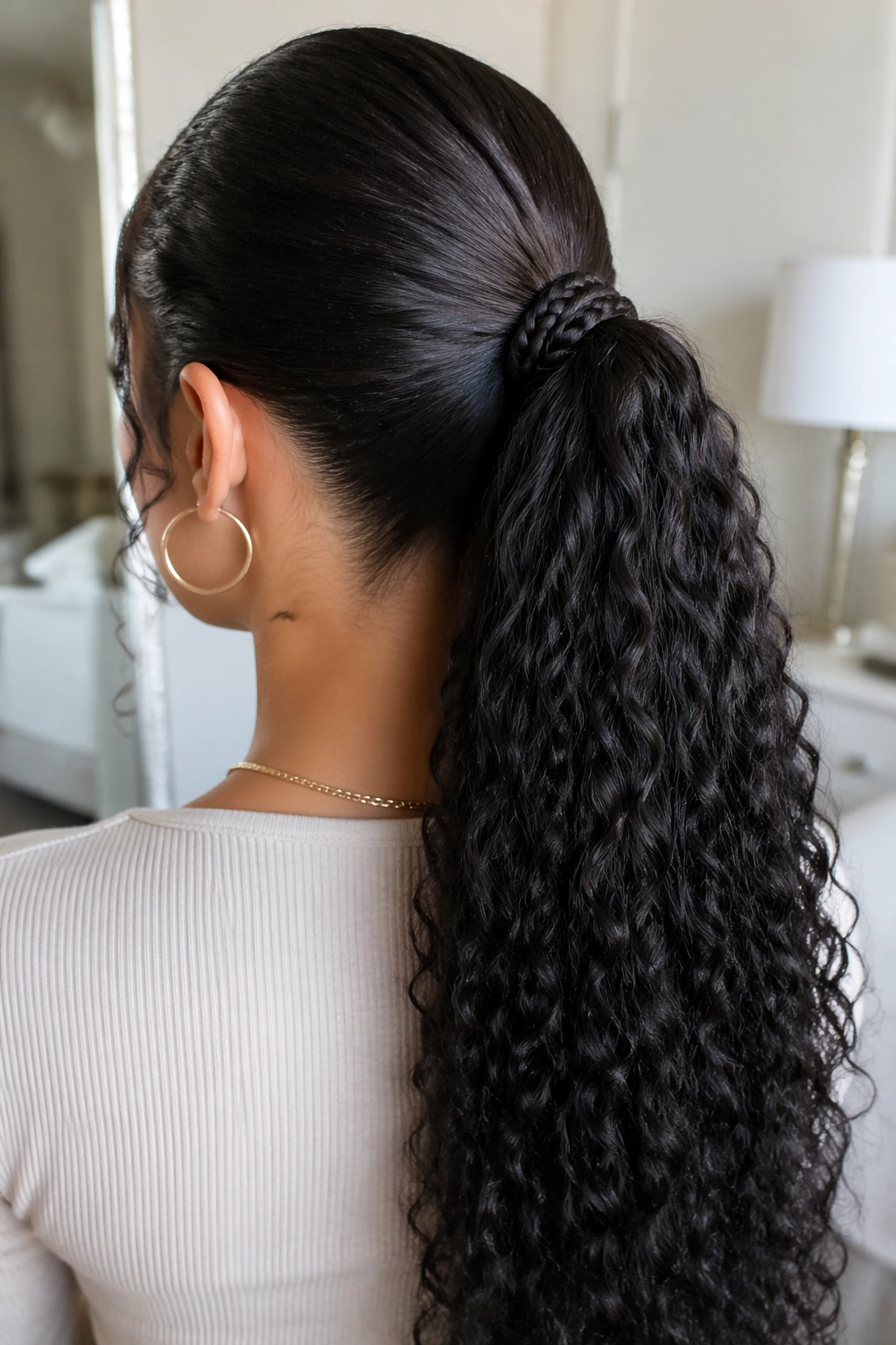 Back view of a real woman showing a hidden-base wrapped braid around the ponytail base.