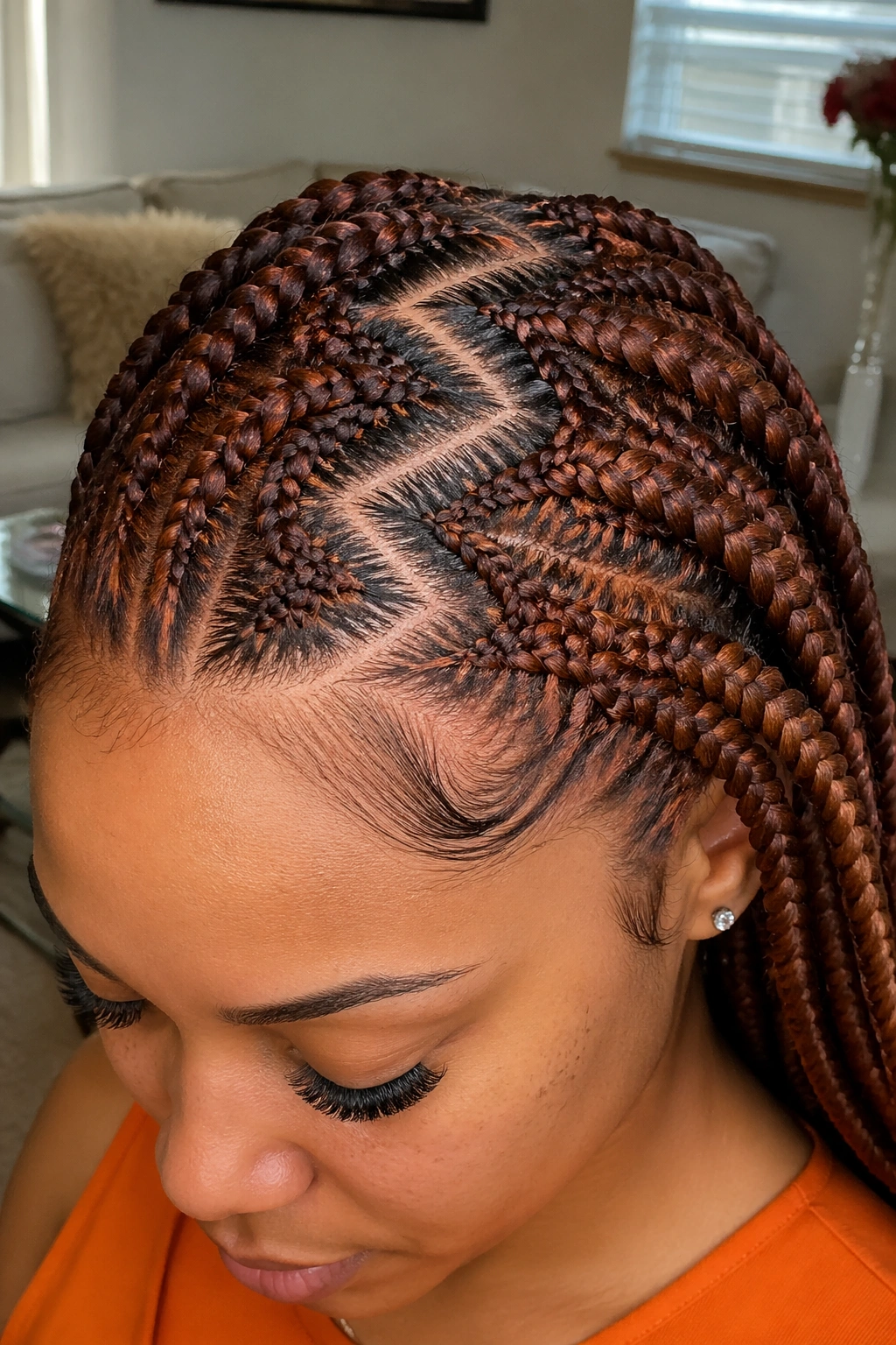 Medium close-up of zigzag-part auburn cornrows on a real person