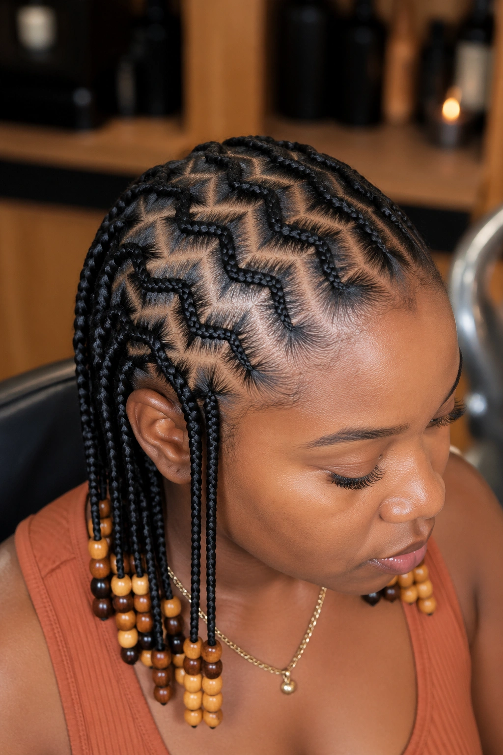 Close-up of zigzag cornrows with beaded ends on a real woman in a warm salon