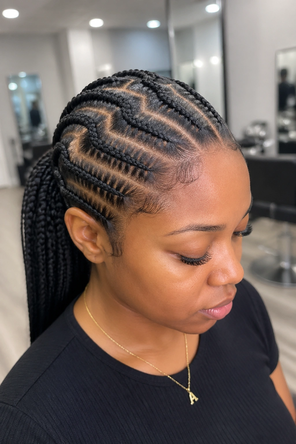 Close-up of a real Black woman with a zigzag-part braided mid ponytail in a salon