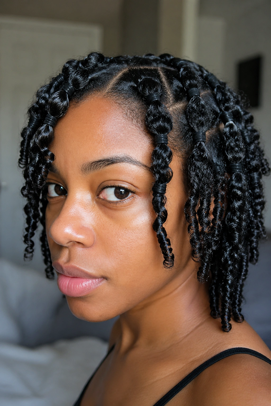 Close-up of a real woman with banded wash-and-go hairstyle showing elastic bands on damp curls