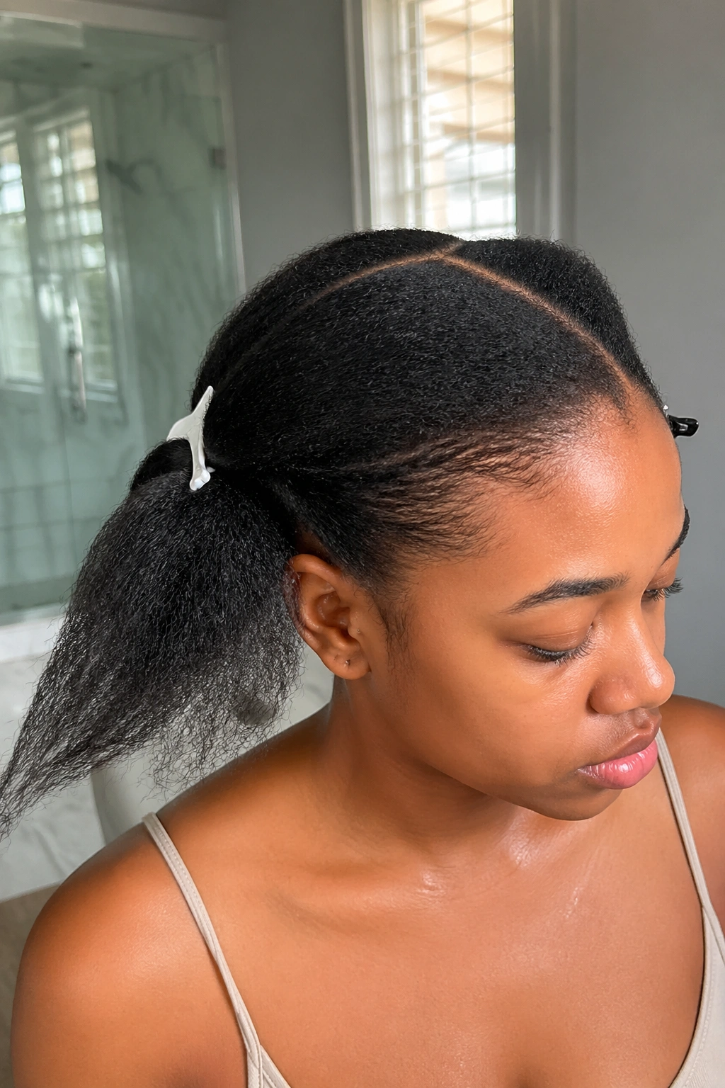 Real person with stretched hair prepped for braiding in a natural-lit setting