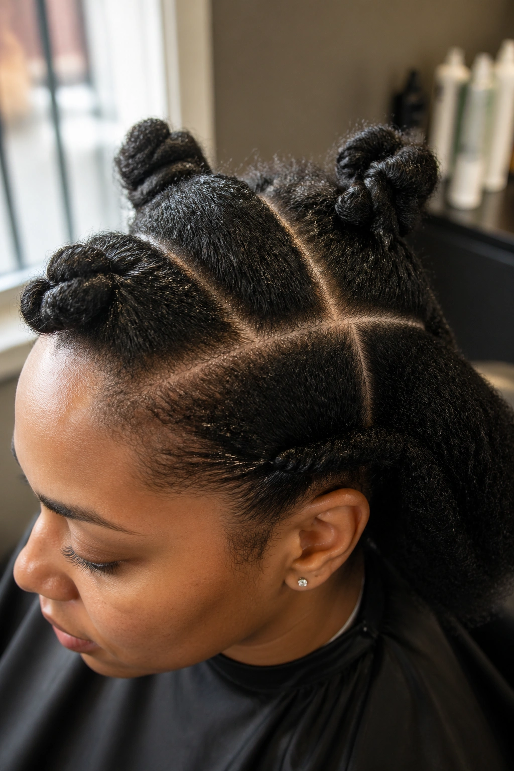Close-up of stretched and moisturized natural hair prepared for cornrow installation.