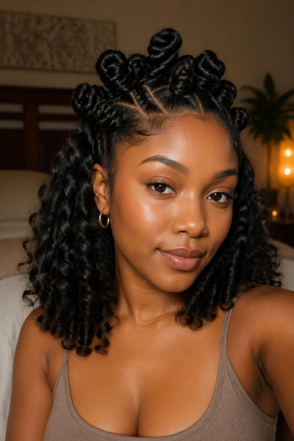 Medium-close portrait of a person with bantu knots on top and loose curls beneath