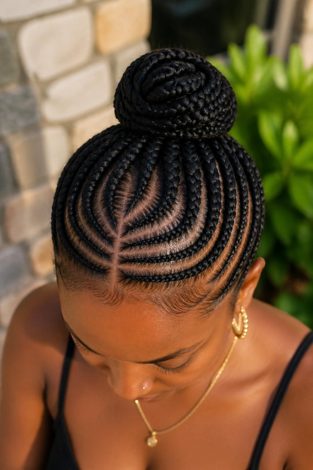 Portrait of woman with halo-pattern cornrows forming a crown around a bun.