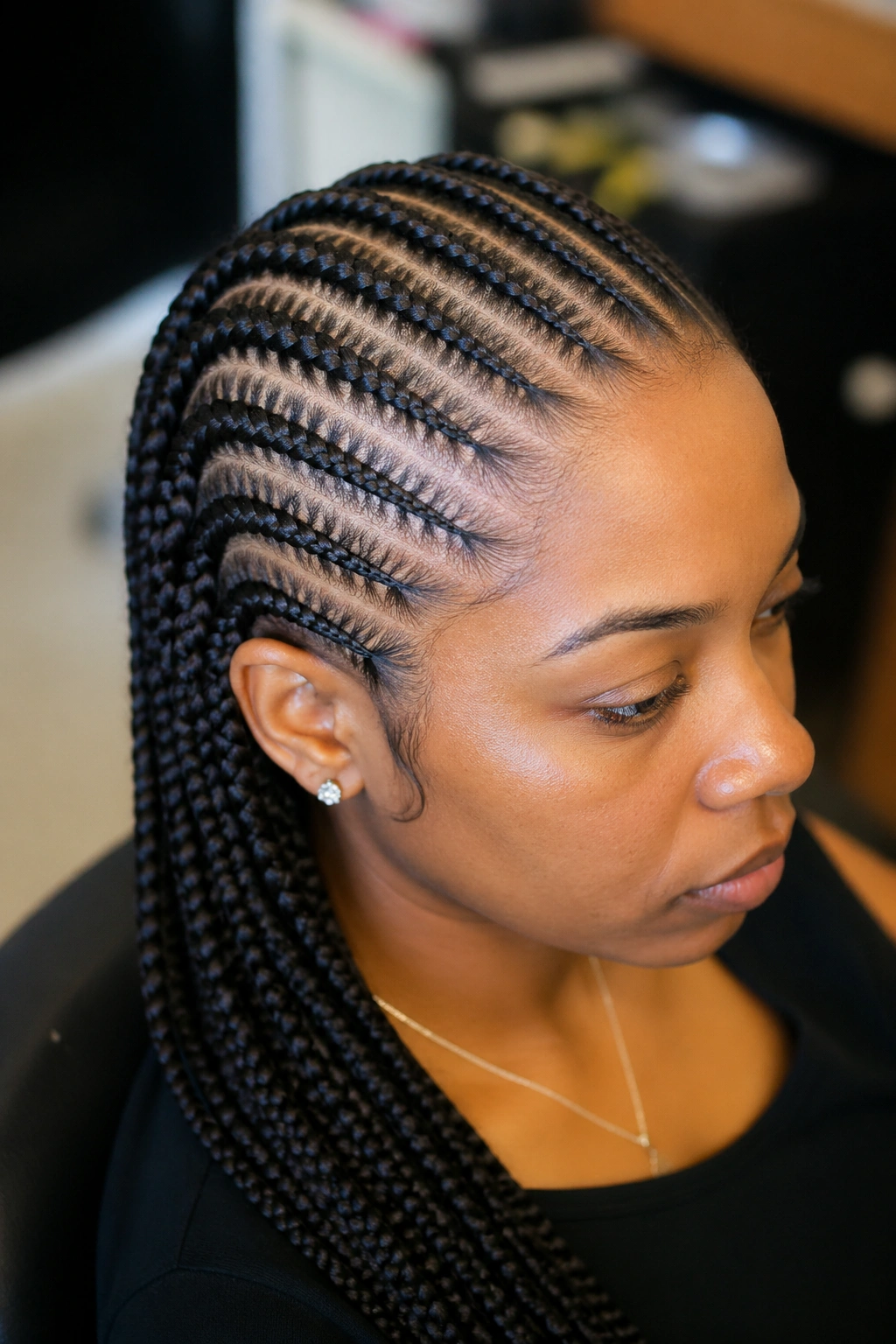 Close-up of knotless cornrows on a real person in a salon