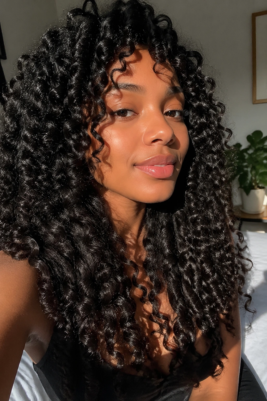Real woman with long sock curl hairstyle in a sunlit bedroom