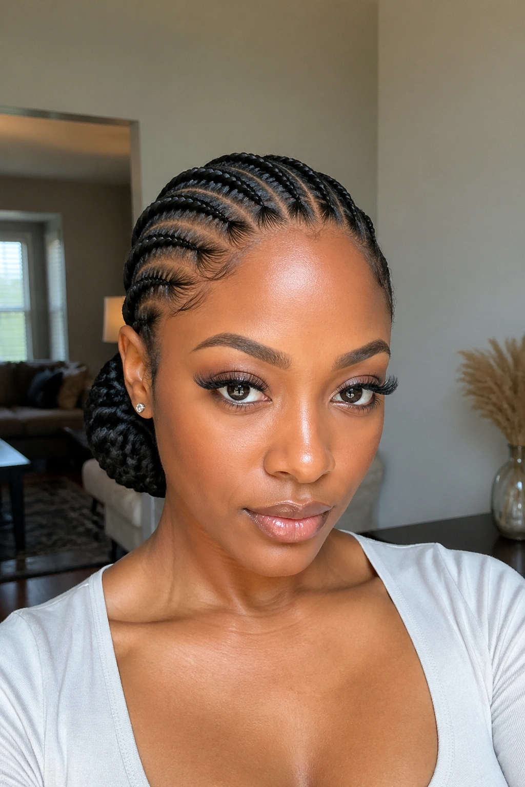 Close-up of a person with a sleek low bun from feed-in cornrows at the nape